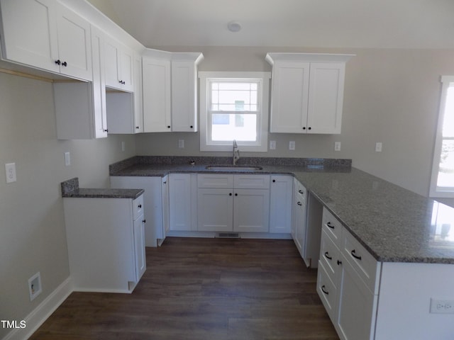 104 Halifax Rd, Louisburg, NC 27549 - kitchen with a peninsula, stone counters, dark wood-style floors, and a sink