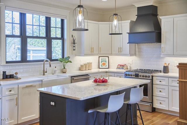 kitchen featuring a center island, sink, appliances with stainless steel finishes, custom range hood, and white cabinets