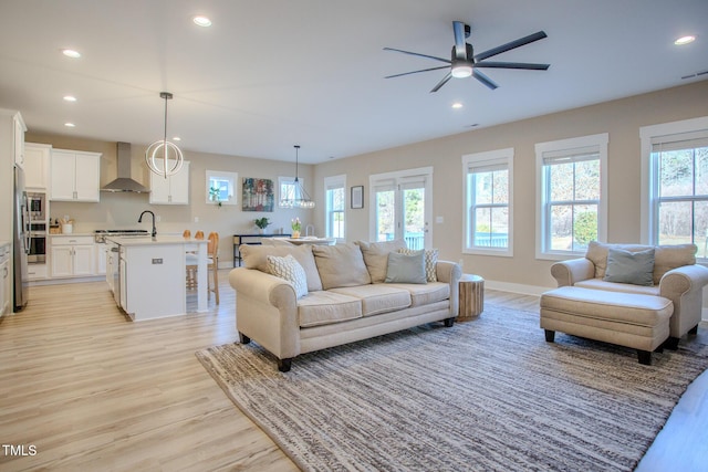 living room with ceiling fan and light hardwood / wood-style flooring