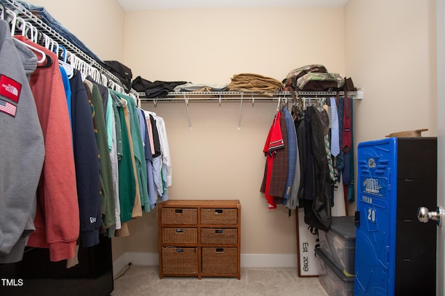 walk in closet featuring light colored carpet