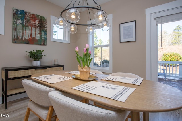 dining space with light wood-type flooring and a chandelier