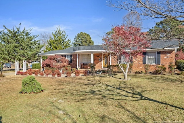 single story home featuring covered porch and a front yard