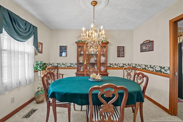 carpeted dining room with a textured ceiling and a notable chandelier