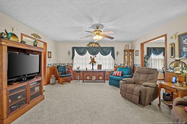 living room with ceiling fan, carpet, plenty of natural light, and a textured ceiling