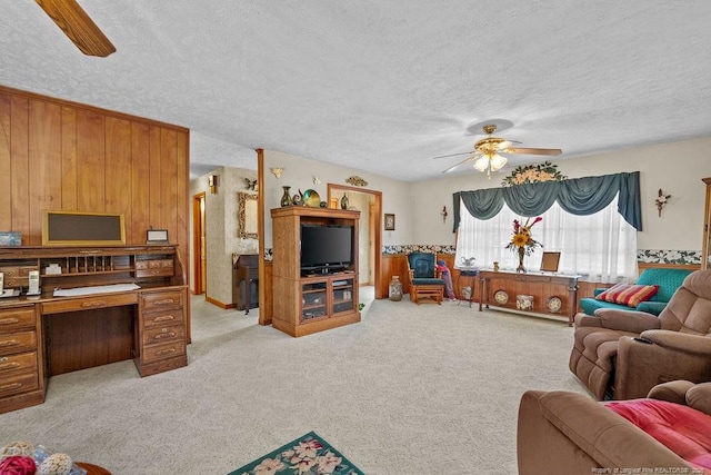 living room featuring a textured ceiling, light colored carpet, and ceiling fan