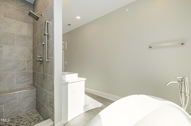 bathroom with tiled shower and tile patterned flooring