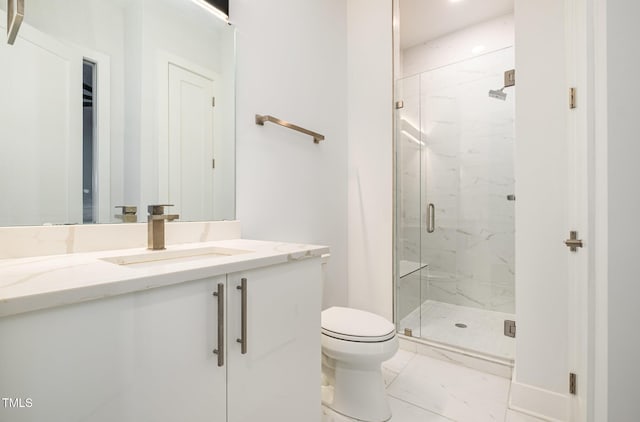 bathroom with toilet, vanity, and a shower with shower door