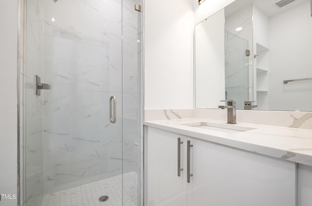 bathroom with a shower with door and vanity