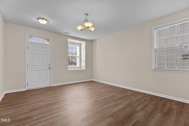 foyer with dark hardwood / wood-style flooring and a notable chandelier