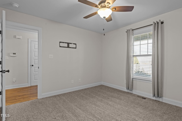 carpeted spare room featuring ceiling fan