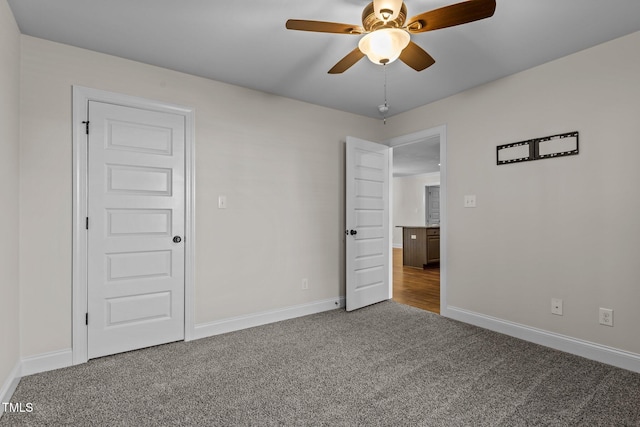 unfurnished bedroom featuring ceiling fan and carpet