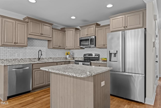 kitchen featuring sink, a center island, ornamental molding, and appliances with stainless steel finishes