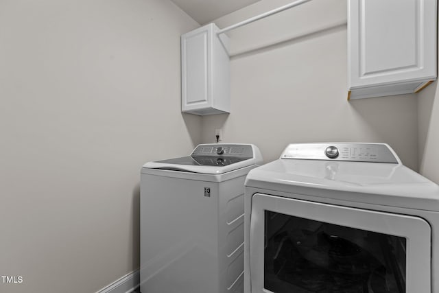 washroom with washer and dryer and cabinets