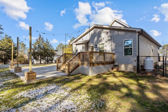 rear view of house with a deck and a yard