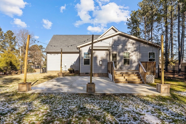 back of property featuring a lawn, a wooden deck, and a patio