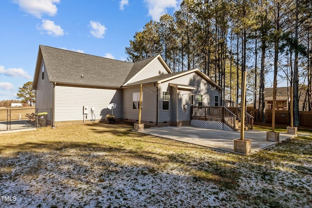 rear view of property with a patio, a wooden deck, and a yard