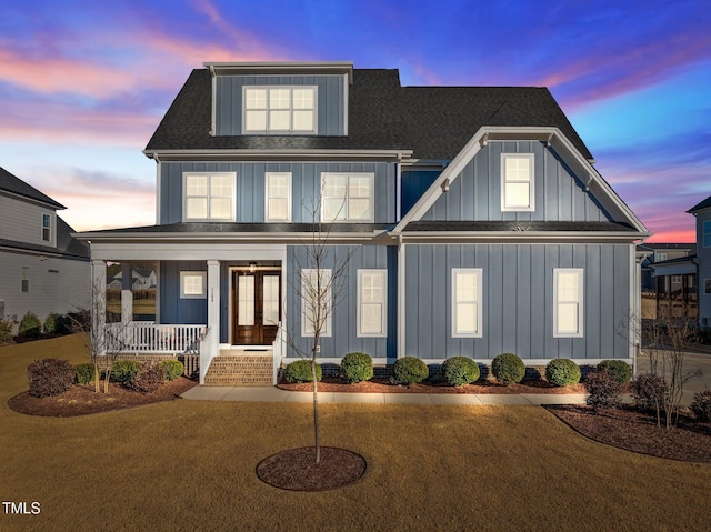 view of front of property featuring a porch, french doors, and a yard