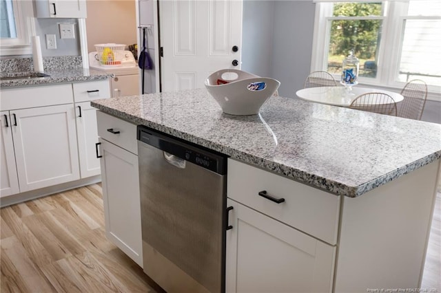 kitchen featuring white cabinetry, dishwasher, light stone counters, and light hardwood / wood-style flooring