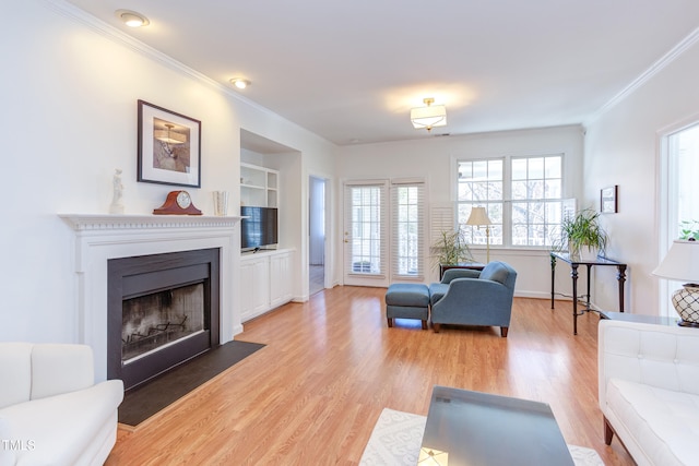 living room with light hardwood / wood-style flooring, crown molding, and built in shelves