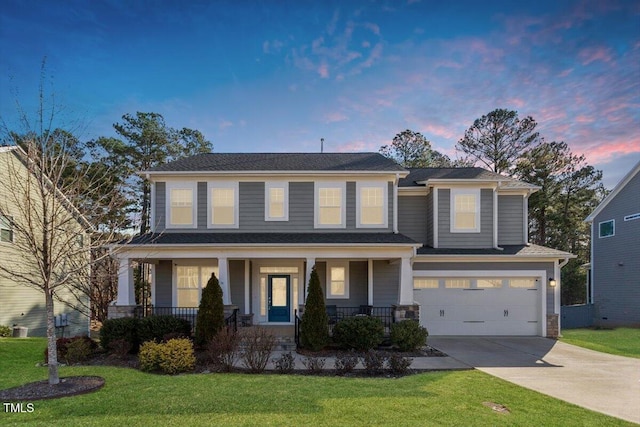 view of front of property featuring a lawn, covered porch, driveway, and an attached garage