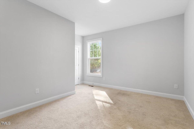 empty room with baseboards and light carpet