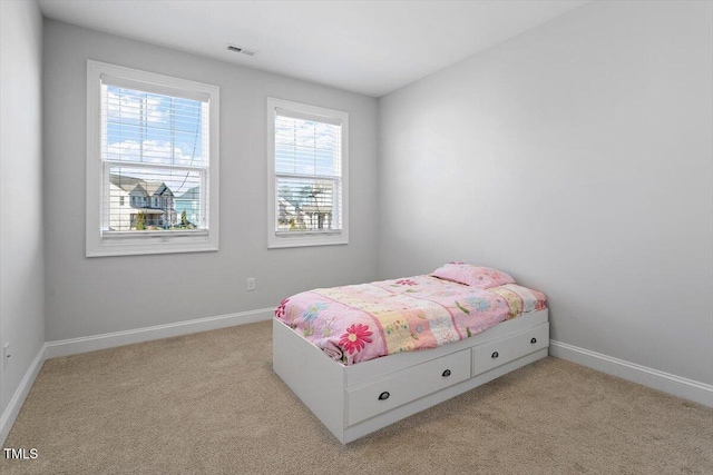 bedroom featuring baseboards, visible vents, and light colored carpet