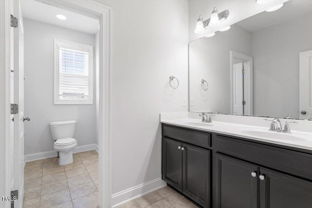 full bathroom with toilet, baseboards, a sink, and tile patterned floors