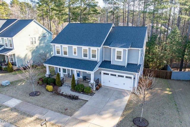 view of front of property with roof with shingles, covered porch, an attached garage, and driveway