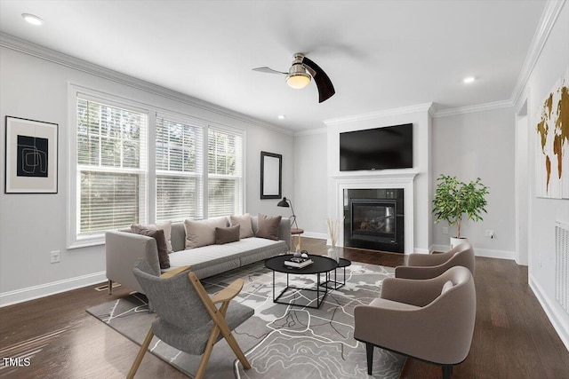 living room featuring crown molding, dark wood-style floors, and a glass covered fireplace