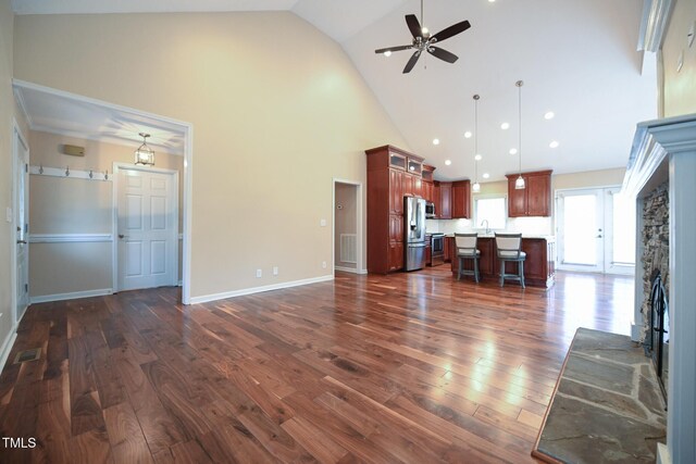 unfurnished living room with dark hardwood / wood-style flooring, sink, high vaulted ceiling, and ceiling fan