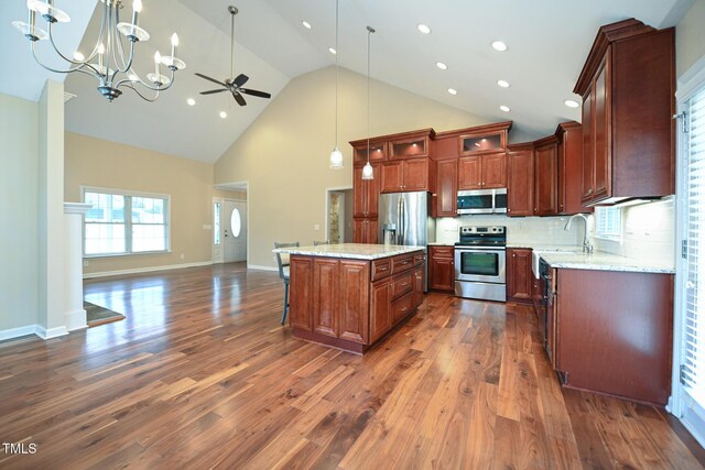 kitchen with sink, dark hardwood / wood-style flooring, hanging light fixtures, a center island, and stainless steel appliances