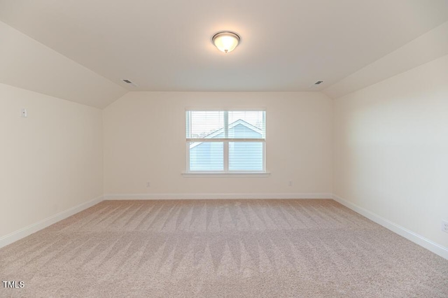 carpeted empty room featuring lofted ceiling