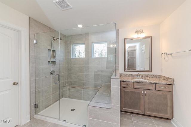 bathroom with an enclosed shower, tile patterned flooring, and vanity