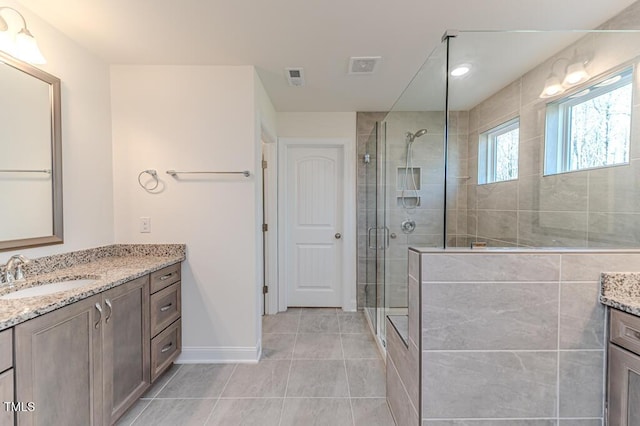 bathroom with a shower with door, tile patterned floors, and vanity