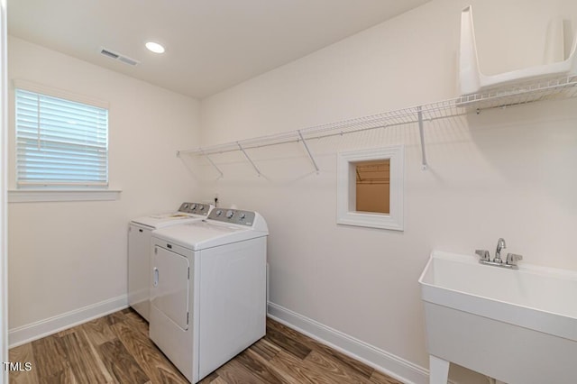 washroom with sink, dark hardwood / wood-style floors, and independent washer and dryer