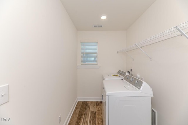 washroom featuring washing machine and clothes dryer and light hardwood / wood-style flooring