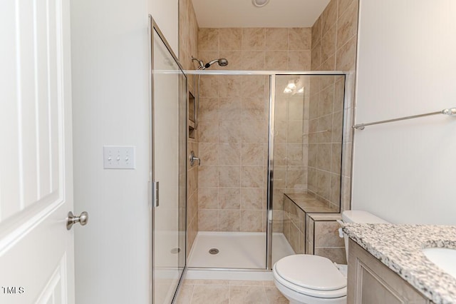 bathroom with toilet, a shower with door, vanity, and tile patterned floors