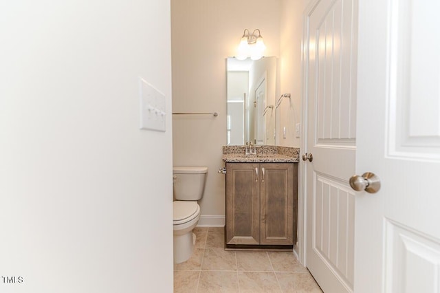 bathroom with toilet, tile patterned floors, and vanity