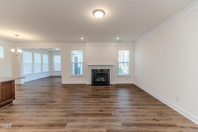 unfurnished living room with a premium fireplace, a chandelier, crown molding, and wood-type flooring