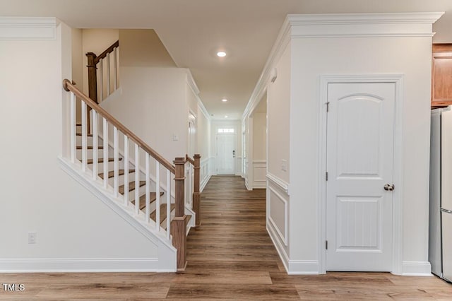 entrance foyer with crown molding and hardwood / wood-style flooring