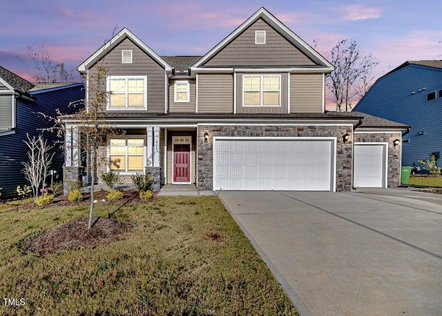 craftsman-style house featuring a garage and a lawn