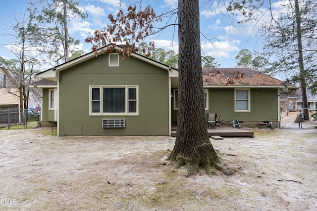 rear view of property with a wooden deck, stucco siding, and fence