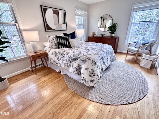 bedroom with light wood-type flooring, multiple windows, and visible vents