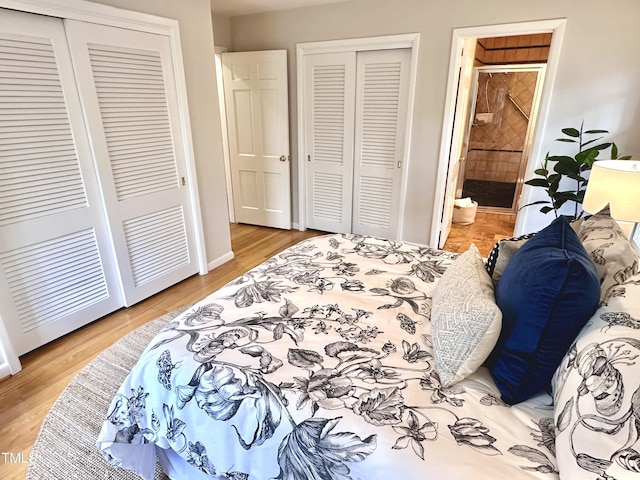 bedroom with light wood-style floors, connected bathroom, baseboards, and two closets