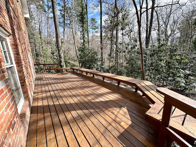 wooden terrace featuring a view of trees