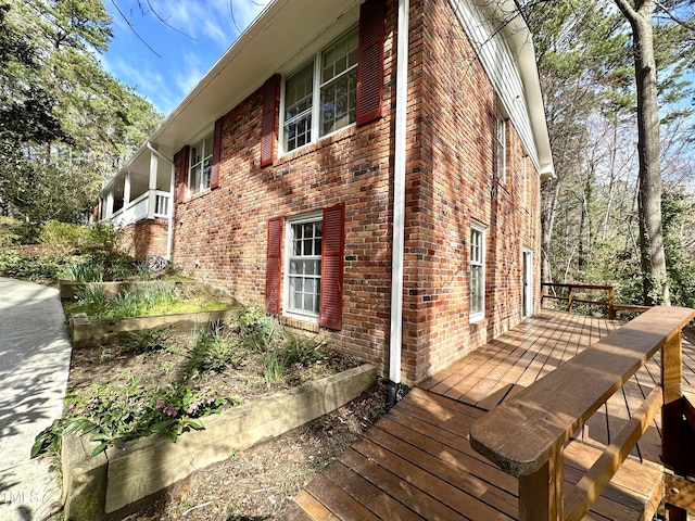 view of home's exterior with a deck and brick siding