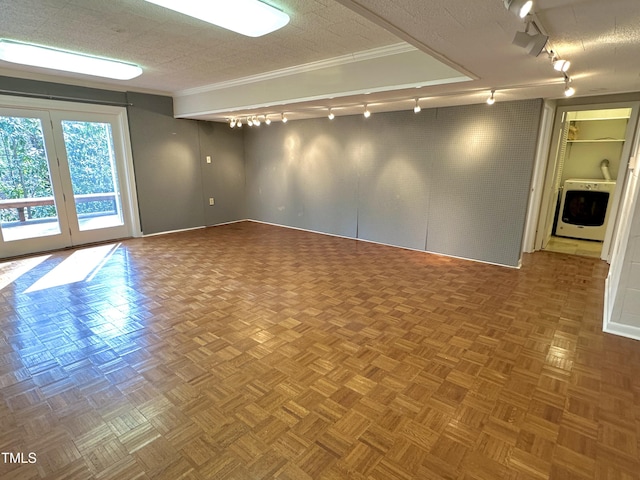 spare room featuring washer / dryer, ornamental molding, a textured ceiling, and track lighting