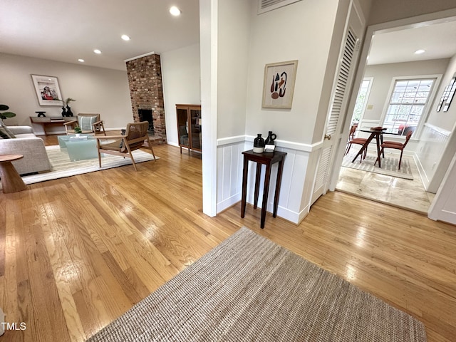 hall featuring wainscoting, light wood-type flooring, and recessed lighting