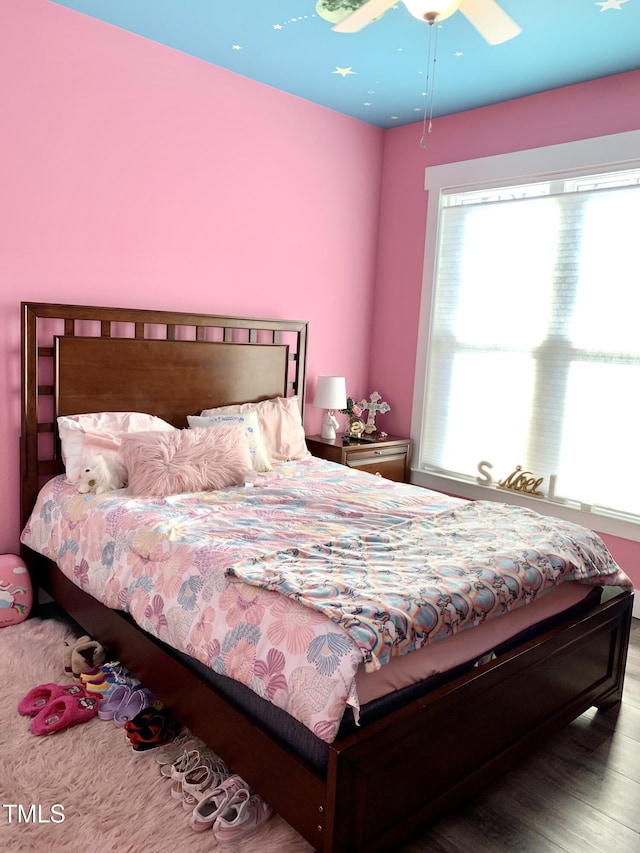 bedroom featuring light wood-type flooring, ceiling fan, and multiple windows