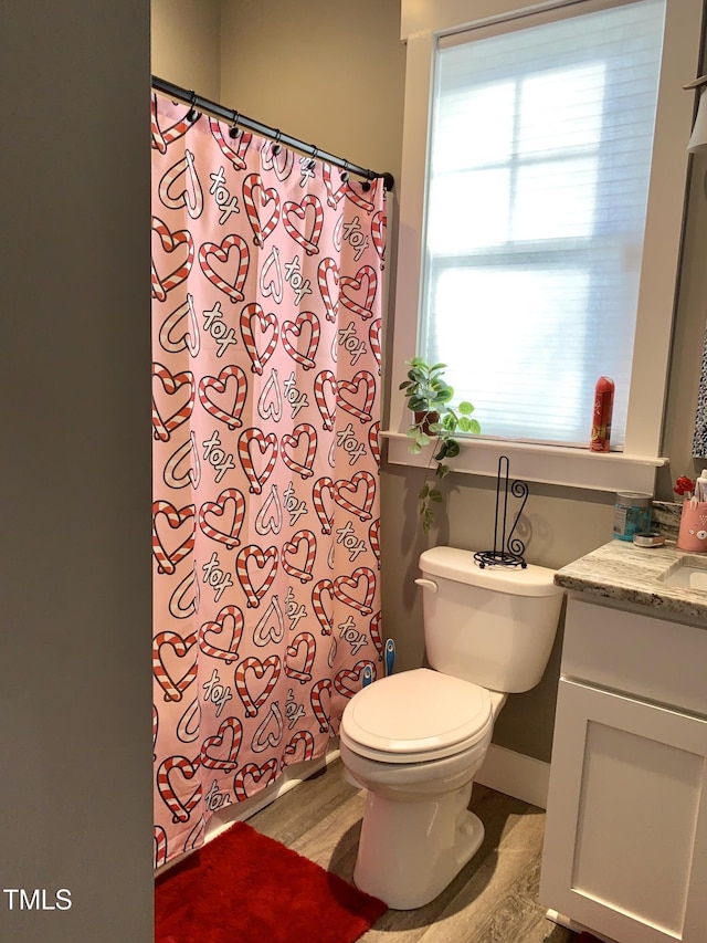 bathroom featuring toilet, walk in shower, and vanity